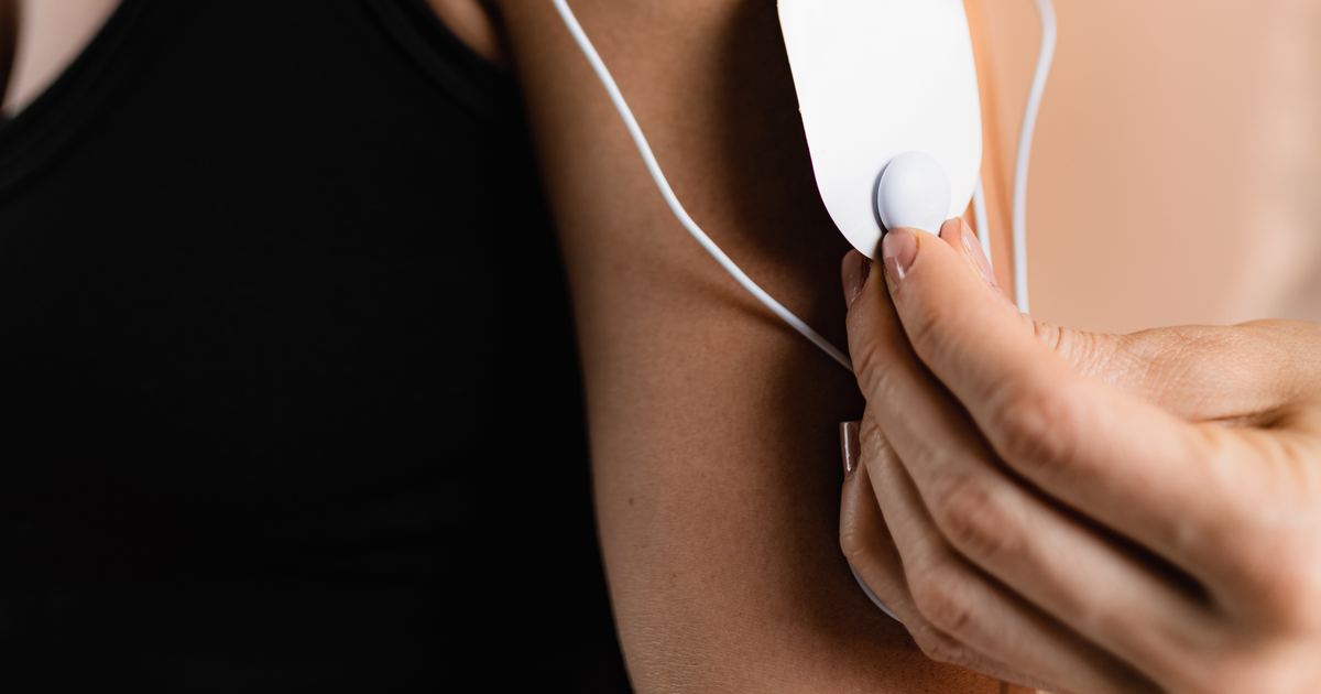 Elektrotherapie als Hausbesuch in München – Physiotherapie Köpple Elektroden einer Reizstromtherapie werden an Schulter und Arm einer Patientin angebracht