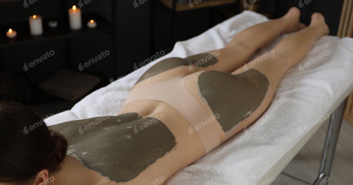 Warme Naturmoorpackung liegt auf dem Rücken einer Patientin während einer Wärmetherapie